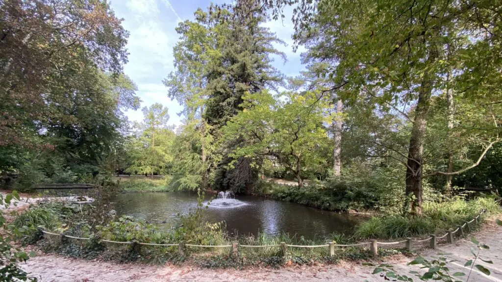 Étang et jet d'eau dans un parc arboré de Bailly, dans les Yvelines