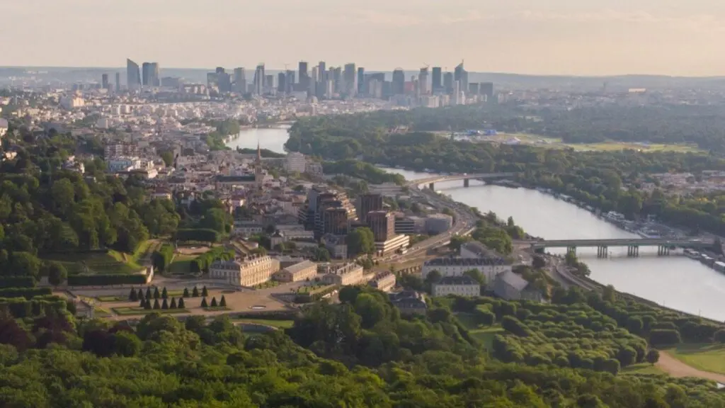 Vue panoramique de Saint-Cloud depuis les hauteurs du parc, avec la Seine et les tours de La Défense à l’horizon