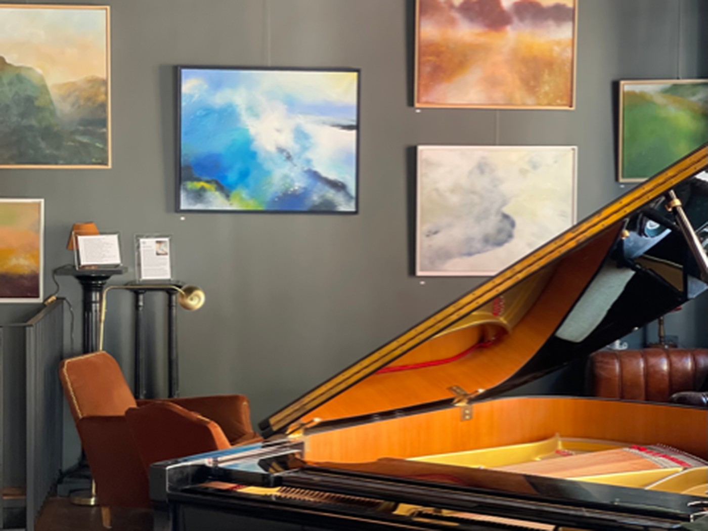 Salle d’exposition de la Galerie Icare à Saint-Cloud : toiles accrochées et piano à queue